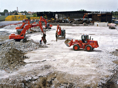 Foto di pale ed escavatori impegnate in una demolizione
