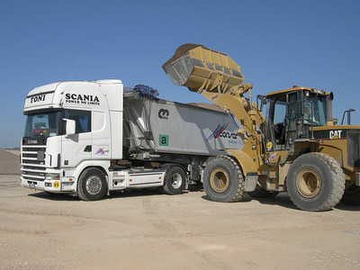 Foto di una pala che carica alcune merci rinfuse su un nostro camion per il trasporto